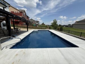 A newly installed rectangular swimming pool with a spacious concrete patio, completed by Acapulco Pool and Spa LLC in Los Angeles, CA