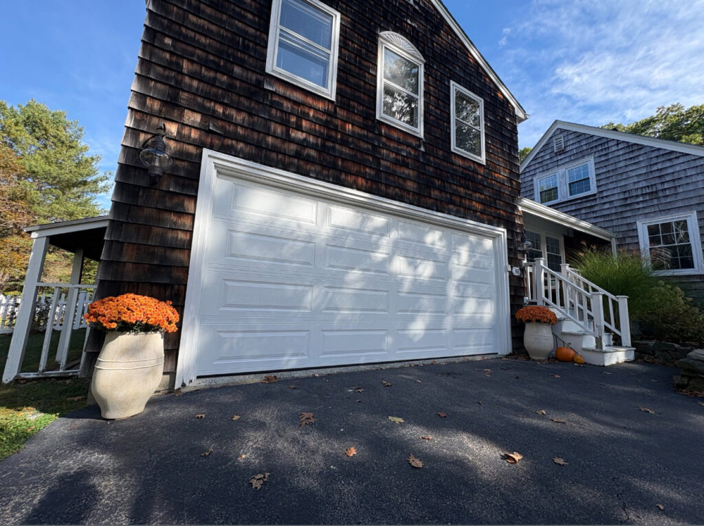 A newly installed white garage door on a residential home by Precision Garage Door Service of NC in Morrisville, NC.