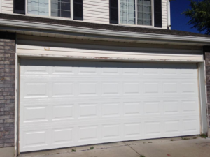 A newly installed white panel garage door on a residential home by Alpine Overhead Garage Door Service in Layton, UT.