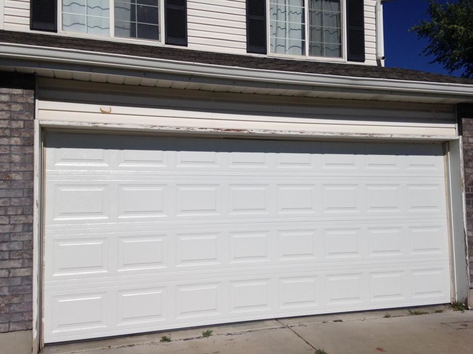 A newly installed white panel garage door on a residential home by Alpine Overhead Garage Door Service in Layton, UT.