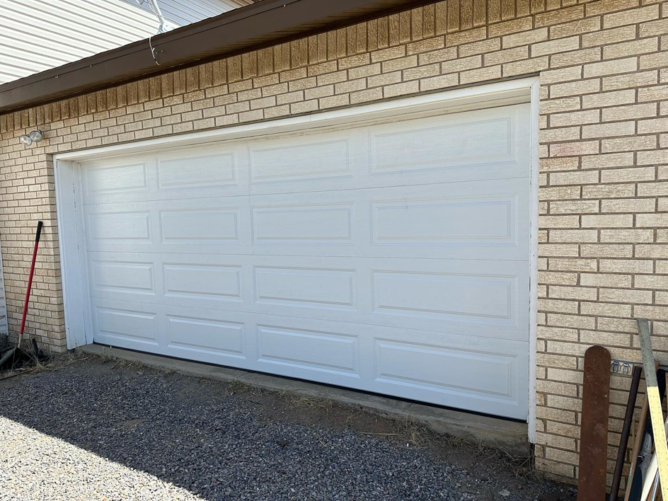 A newly installed white panel garage door by Espada Garage Door and Gate, LLC, providing quality service in Las Cruces, NM.