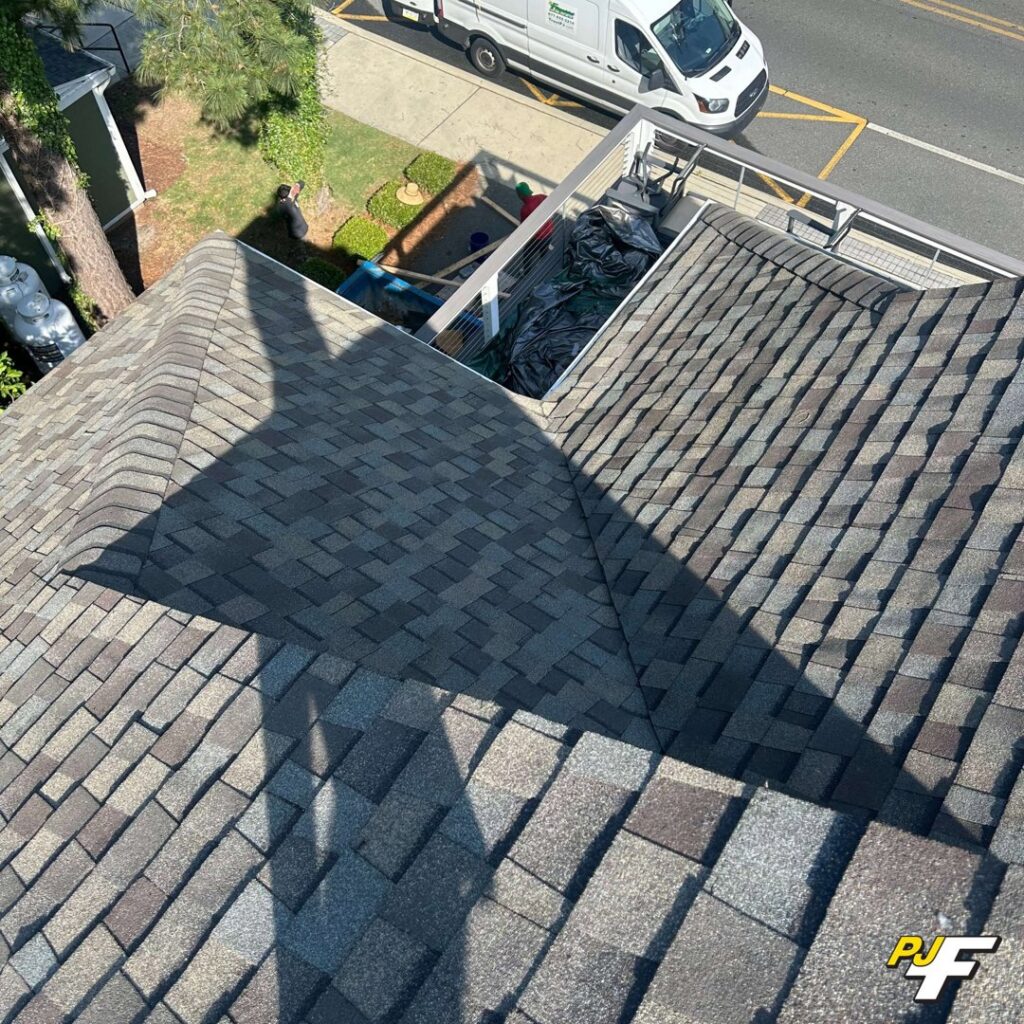 An aerial view of a newly shingled roof installation completed by PJ Fitzpatrick LLC in New Castle, DE, crucial for water damage prevention.