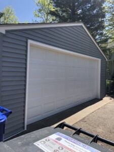 Newly sided garage with modern gray siding and a white garage door by Capital Siding, Windows & Roofing, Woodbury, MN.