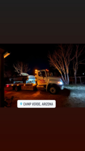 Sotelo Towing LLC providing night towing service for a car on a flatbed tow truck in Phoenix, AZ.