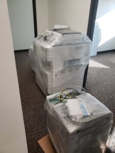 Two large office machines carefully wrapped for moving by Ron's Moving in Little Rock, AR.