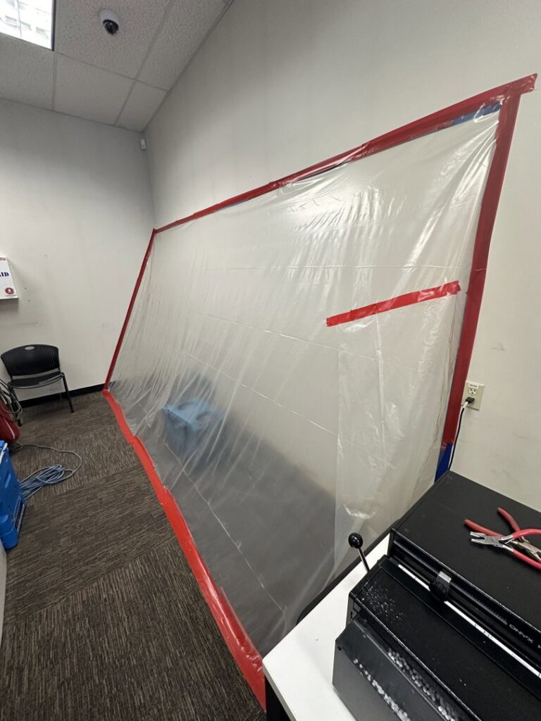 Office with large plastic containment barrier for water damage or mold remediation by Brothers Restoration in Post Falls, ID.