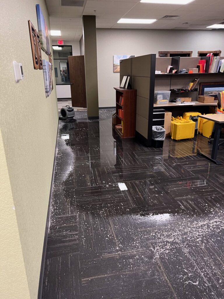 An office space with standing water on the carpet and drying equipment from Specialized Cleaning & Restoration, Inc. in Bismarck, ND.