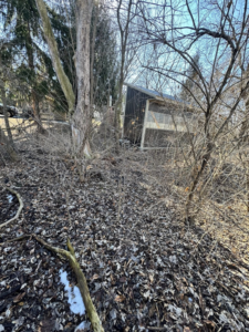 An old outbuilding in a wooded area ready for demolition by R & S General Services LLC in Racine, WI