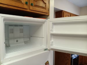An open, spotless refrigerator in a kitchen, showcasing the results of KB Cleaning services in Bozeman, MT.