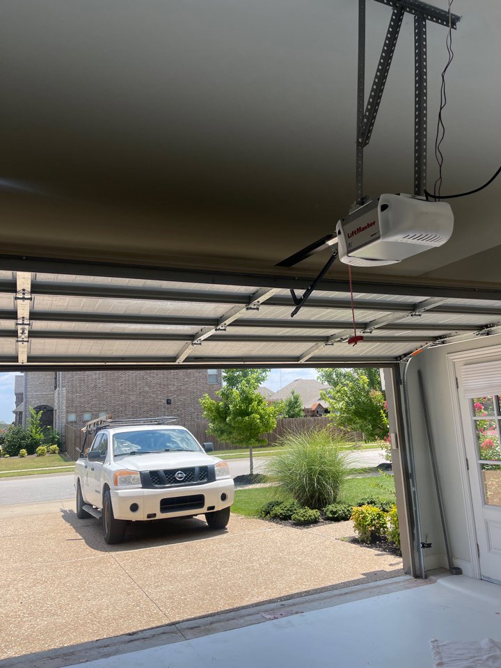 View from inside a garage showing an open door and LiftMaster opener system by Garage Doors & More in Bentonville, AR