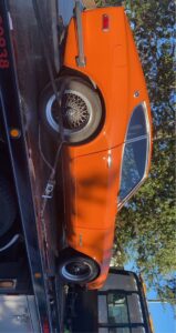 An orange classic car secured on a flatbed tow truck by 101 auto towing inc in San Jose, CA.