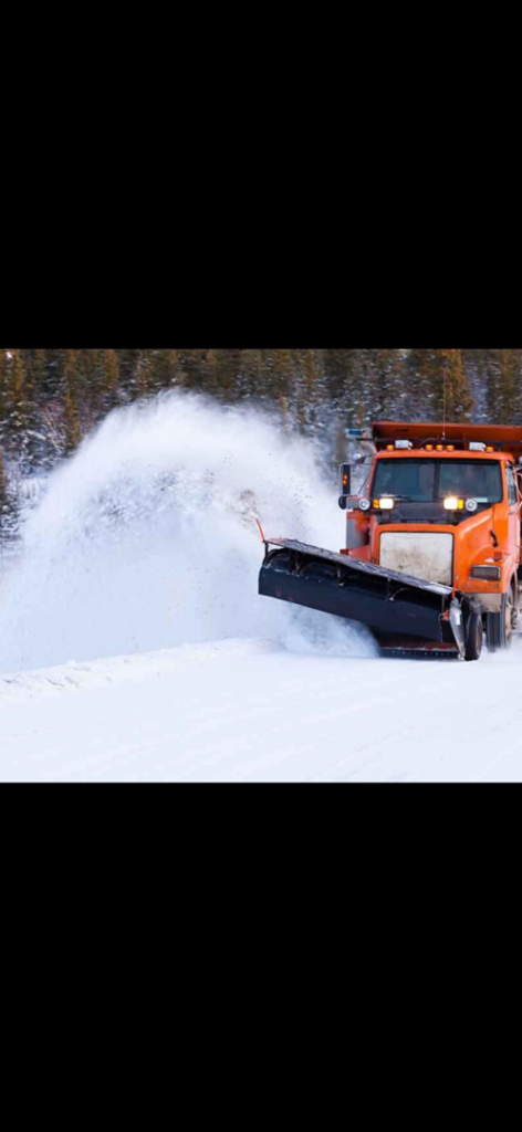 An orange snowplow truck actively clearing snow from a road for Royal Snow Removal in Gresham, OR.