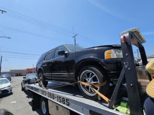 An Orellanas Towing flatbed truck transporting a black SUV in Los Angeles, CA.
