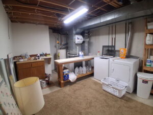 An organized basement storage area with neatly arranged shelves, showcasing the results of professional cleaning by CleanSlate Cleaning Company in Lansing, MI.