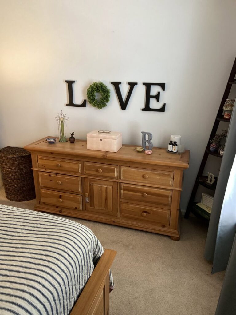 A beautifully organized bedroom dresser with decorative items, a result of Consciously Cleared & Contained LLC in Elsmere, DE.