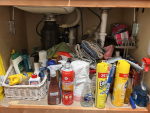 An organized cabinet under a kitchen sink after professional cleaning by On Course Cleaning in Fayetteville, NC.