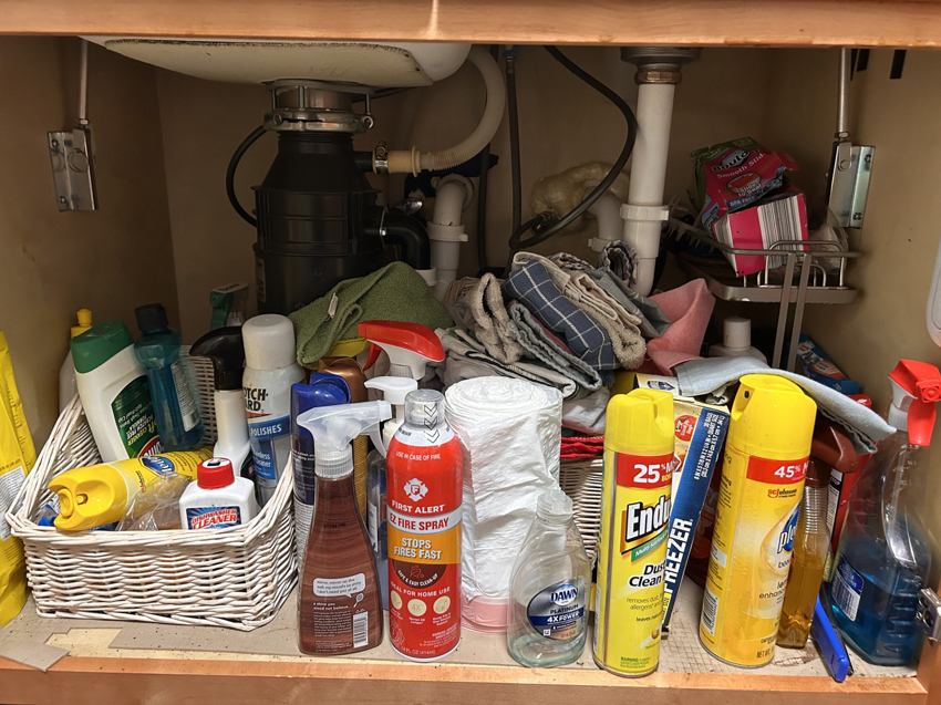 An organized cabinet under a kitchen sink after professional cleaning by On Course Cleaning in Fayetteville, NC.