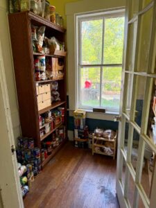 An organized pantry with shelves full of food and supplies by KDG Decluttering in Manchester, NH.