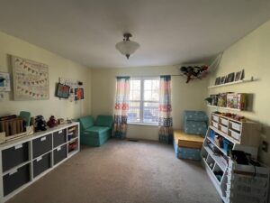 A bright, organized playroom with storage shelves and bins by Consciously Cleared & Contained LLC in Elsmere, DE.
