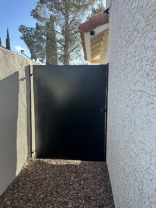 An ornate black iron pedestrian gate with a screen installed by Giddy Up Garage Doors & Iron in Las Vegas, NV.