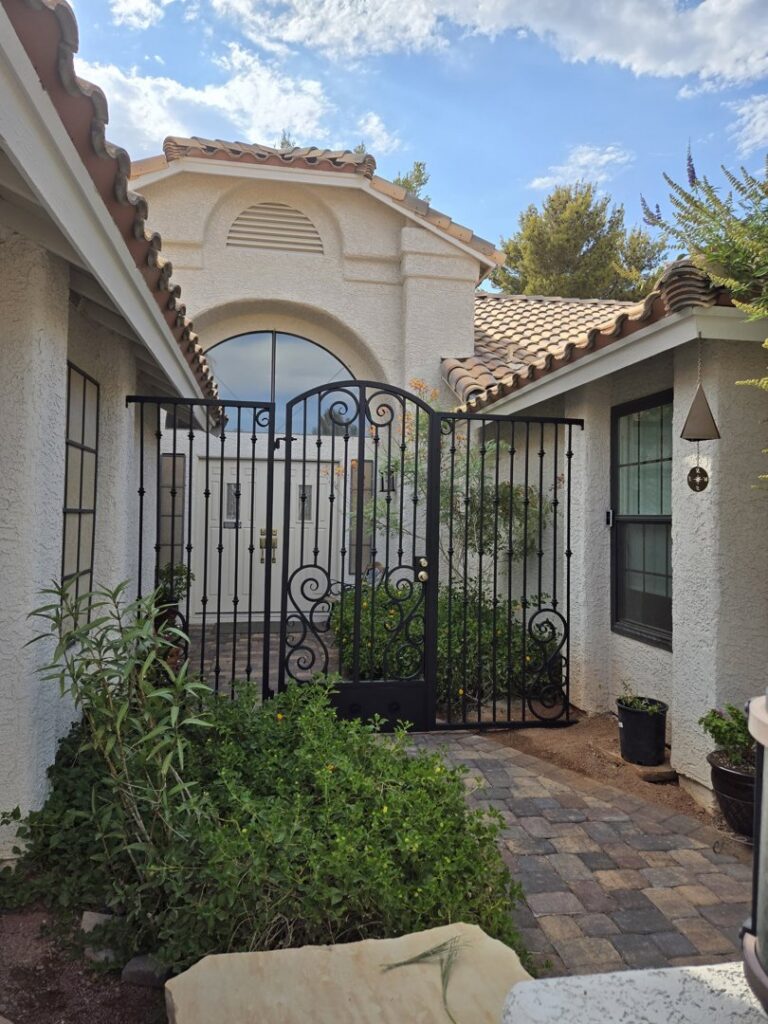 An ornate wrought iron courtyard gate installed by Giddy Up Garage Doors & Iron in Las Vegas, NV.