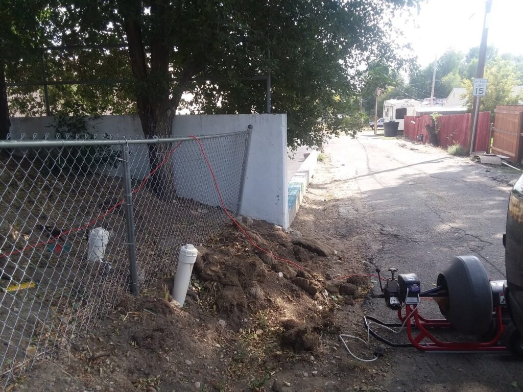 An outdoor drain cleaning service in progress with equipment near a cleanout by Central Wyoming Drain Service in Casper, WY.