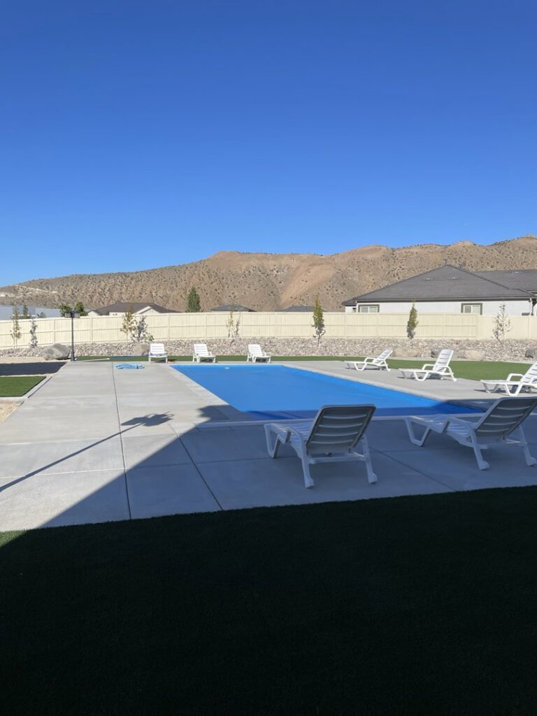 An outdoor swimming pool with a protective blue cover, installed by Battle Born Pool & Spa in Sparks, NV.