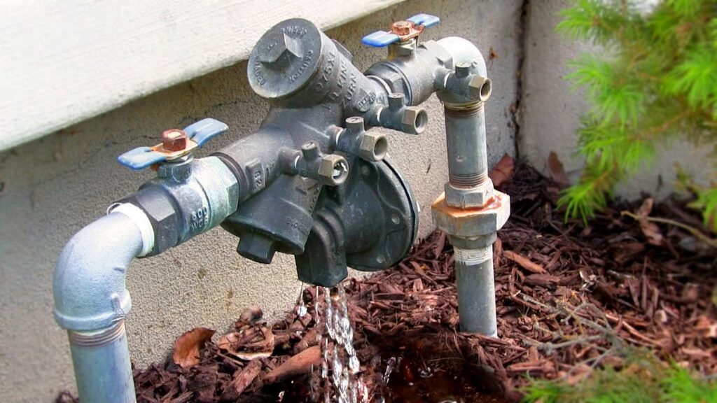 An outdoor water pipe leaking, requiring repair by SMART Plumbing Hawaii, a water damage specialist in Hilo, HI.