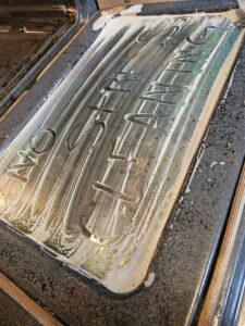 An oven door being cleaned with foam, showing "No Stress Cleaning" written, by No Stress Cleaning Services in Virginia Beach, VA