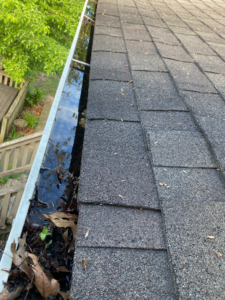 An overflowing gutter filled with water and debris, indicating potential water damage issues, addressed by Valor Restoration in Richmond, KY