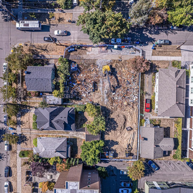 An overhead view of a residential demolition site with an excavator and debris, handled by Rainstate Earthworks in Auburn, WA.
