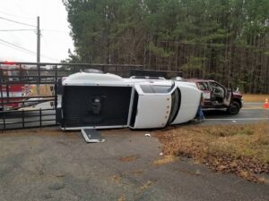 An overturned pickup truck on the side of a road, awaiting recovery by Raleigh Towing & Recovery in Raleigh, NC.