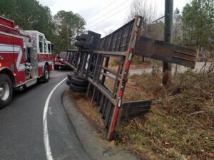 An overturned trailer on the side of a road, part of a recovery operation by Raleigh Towing & Recovery in Raleigh, NC.