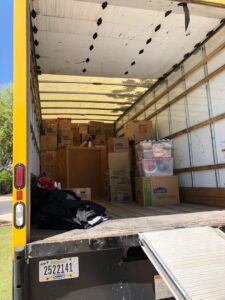 A moving truck fully loaded with boxes and household items, with the ramp extended, ready for transport by Academy Movers in Gilbert, AZ.