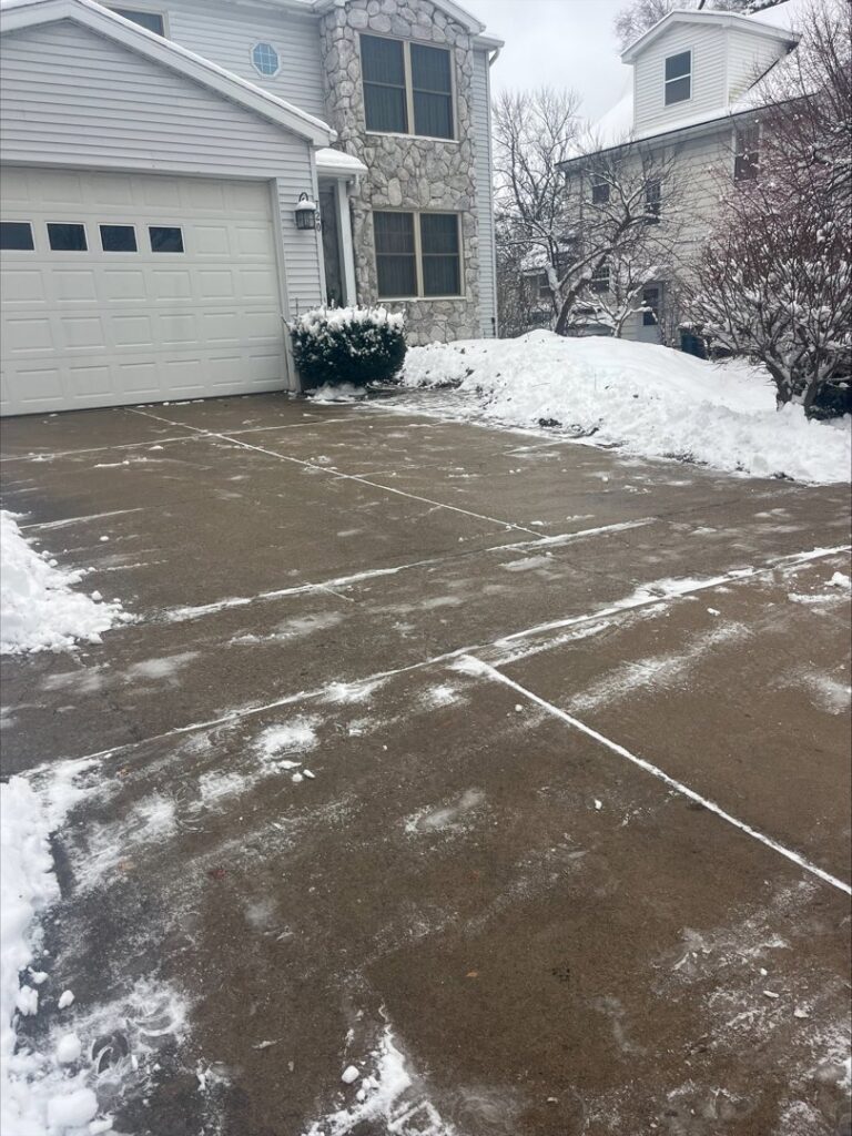 A residential driveway partially cleared of snow by Snow Scholars - Snow Removal By College Students in Madison, WI.