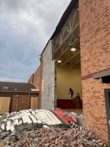 Partially demolished brick building with debris, showing a demolition project by Cornerstone Demolition & Excavation in Lexington, KY