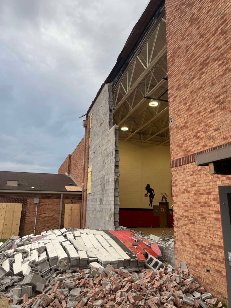 Partially demolished brick building with debris, showing a demolition project by Cornerstone Demolition & Excavation in Lexington, KY