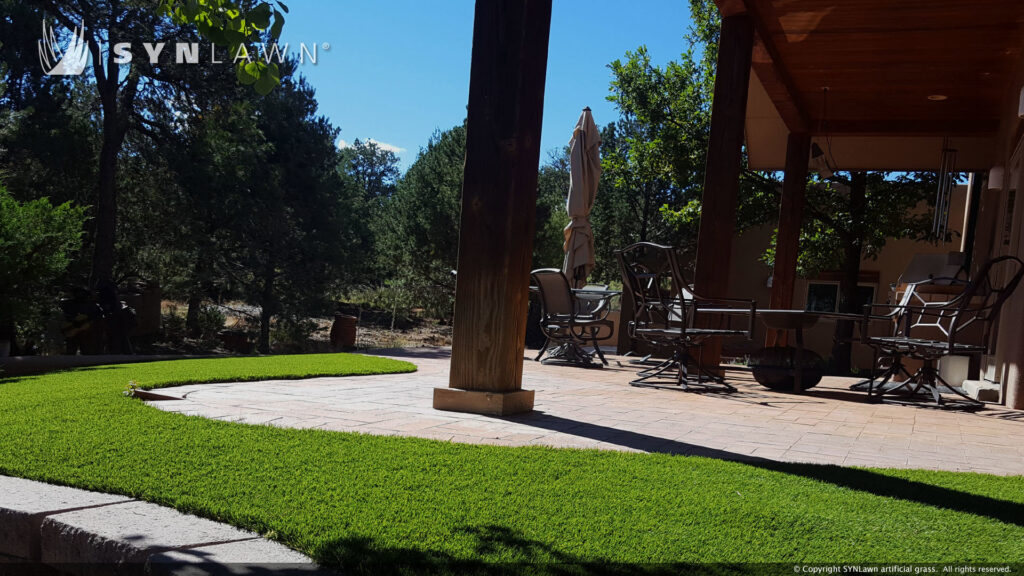 An outdoor patio area with artificial grass landscaping by SYNLawn of New Mexico in Albuquerque, NM.