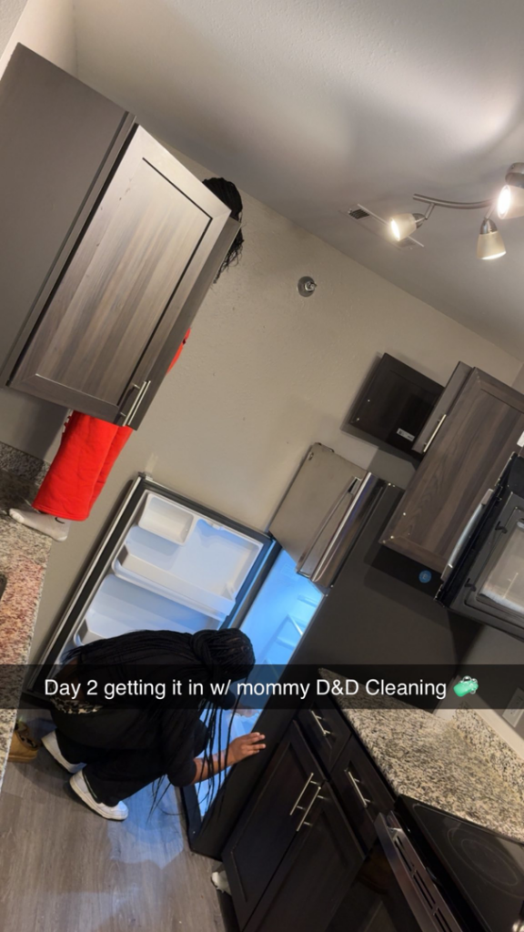 A person cleaning the interior of a refrigerator in a kitchen, demonstrating a house cleaner service by Down And Dirty Cleaning in Clayton, NC.