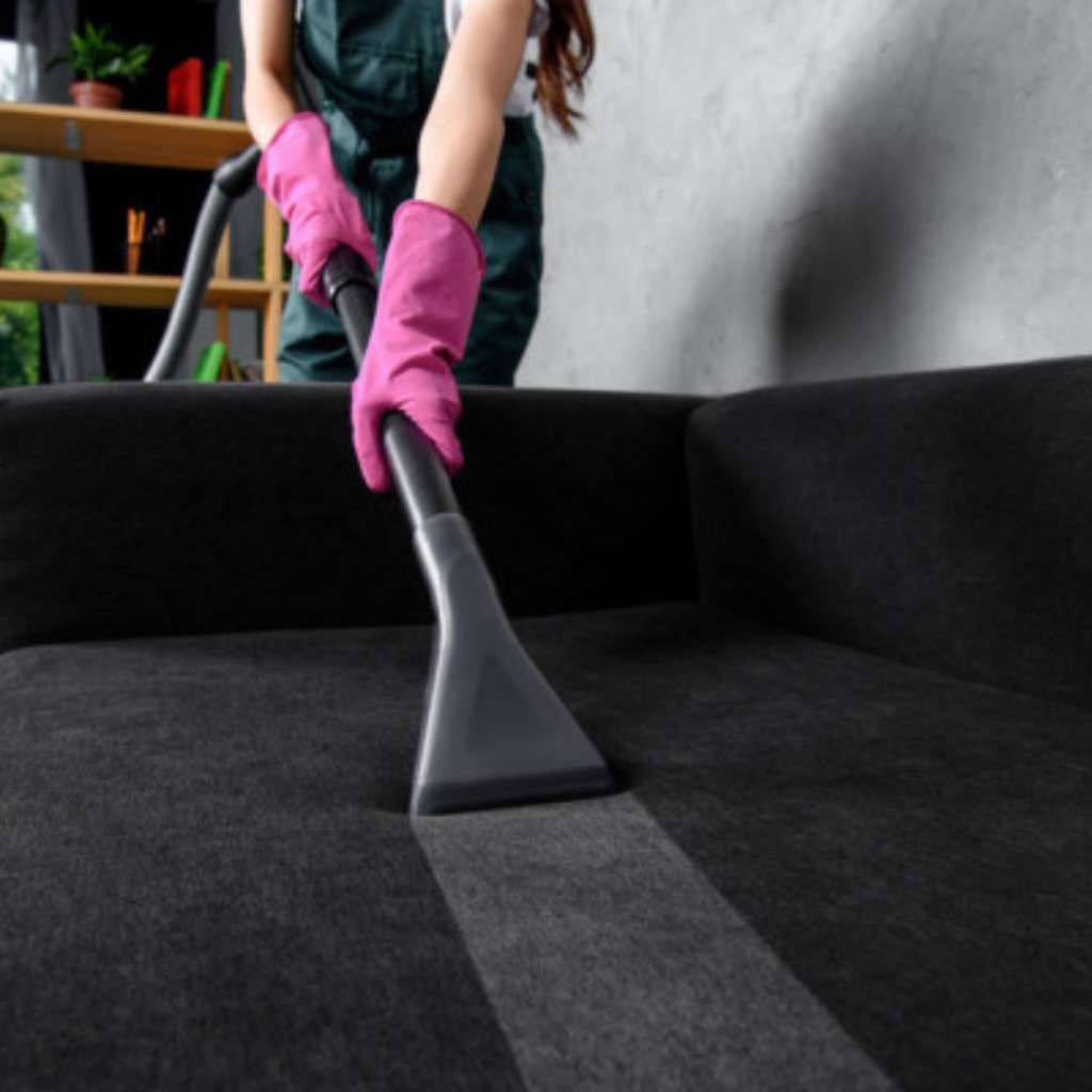 A professional cleaner in pink gloves deep cleaning sofa upholstery at Phoenix Move Out House Cleaning Pros in Chandler, AZ