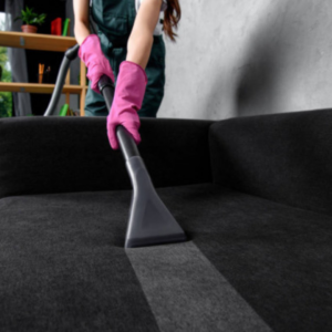 A professional cleaner in pink gloves deep cleaning sofa upholstery at Phoenix Move Out House Cleaning Pros in Chandler, AZ