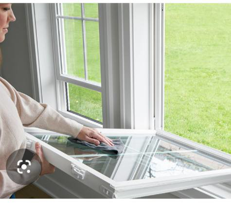 A person meticulously cleaning a window pane with a cloth, demonstrating house cleaning services by Keepin It Kleen in Seaford, DE.