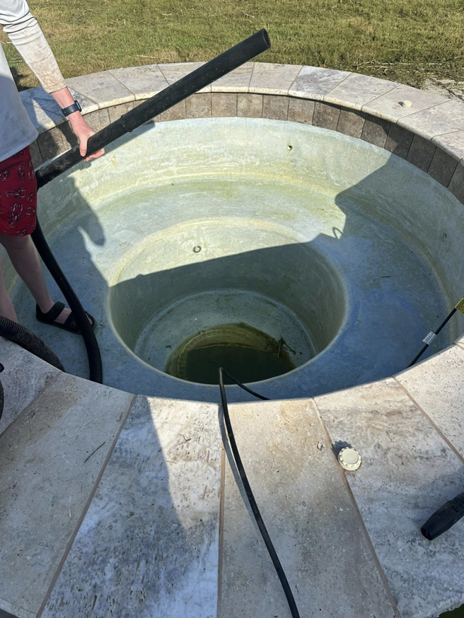 A technician from Stephens Pool Service draining a dirty spa in Oklahoma City, OK.
