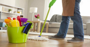 A person in green gloves mopping a clean floor with a bucket of cleaning supplies at Sparkle & Shine of Iowa in Urbandale, IA.