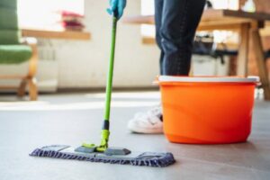 A person mopping a floor in a bright residential room, showcasing house cleaning services by Full Circle Commercial Cleaning in Scottsdale, AZ.