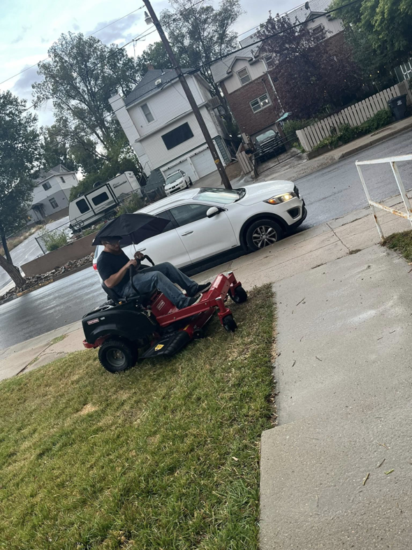 A person operating a riding lawn mower on a residential lawn, providing professional mowing services for ResClean Property Maintenance in Rock Springs, WY.