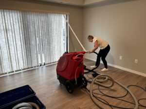 A professional from FM Cleaning operating a floor cleaning machine on hard flooring in a home in West Fargo, ND.