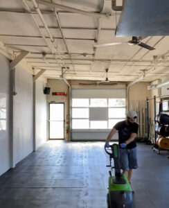 A person operating a professional floor scrubber for Clean Sweeper Cleaning Services in Melrose, MA