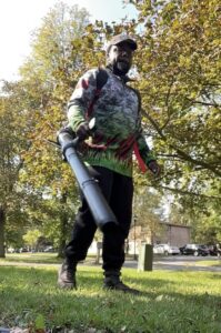 A person using a snow blower to clear a residential driveway, a service offered by Knight's Landscaping & Snow Removal in Buffalo, NY.