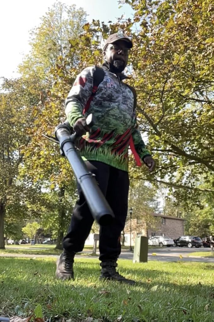 A person using a snow blower to clear a residential driveway, a service offered by Knight's Landscaping & Snow Removal in Buffalo, NY.